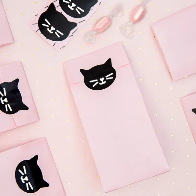 Roze zakjes dichtgeplakt met een zwarte sticker in de vorm van een kat