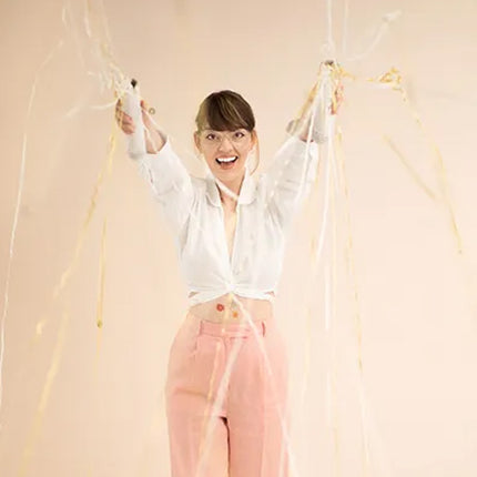 Vrouw gebruikt twee confetti sticks met streamers