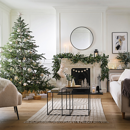 Huiskamer versierd met witte, groene en houten kerstversiering