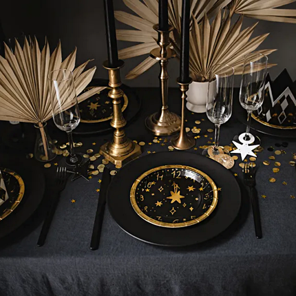 Tafel gedekt voor oud en nieuw met zwarte en gouden versiering