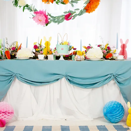 Tafel met wit en blauw tafelkleed versierd met honeycombs in het geel, roze, blauw en groen