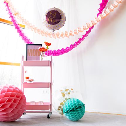 roze slingers hangen over een roze karretje met moederdag versiering