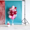 Heliumtank met rode, roze en transparante ballonnen met hartjes
