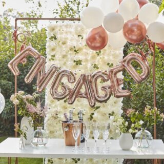 Versierde tafel met champagne en daarboven een folieballon met de tekst engaged