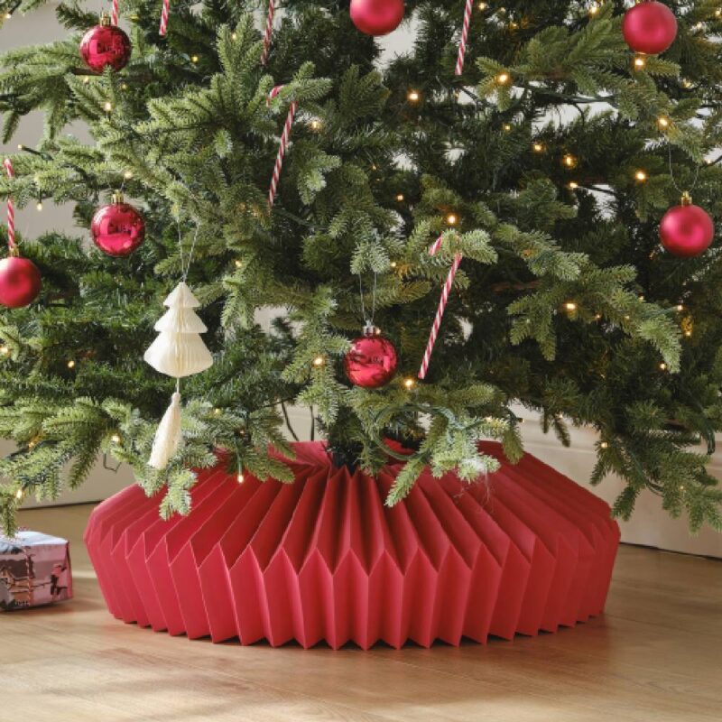 Kerstboom met rode kerstboomrok eronder