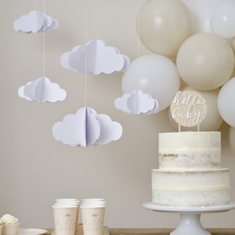 Hangende 3D wolken hangen boven een houten tafel versierd met cremekleurige bekers en een taart met een houter taarttopper en beige ballonnen