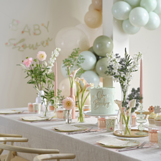 Babyshower met groene versiering met bloemen en nude kleuren