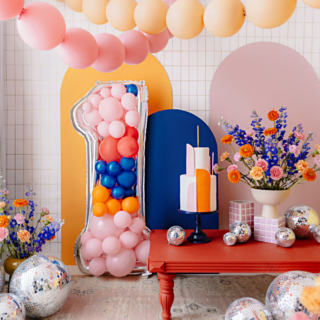versiering woonkamer met ballonnen slingers en discoballen en een reuze cijfer 1