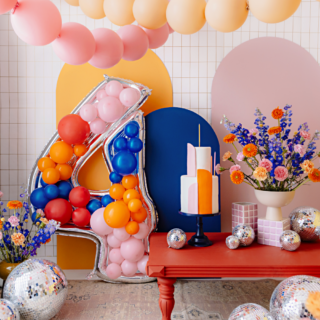 versierde woonkamer met ballonnen slingers en discoballen en een reuze cijfer