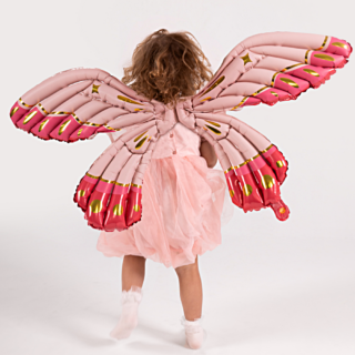 folieballon in de vorm van een vlinder zit op de rug van een meisje