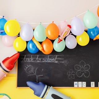 ballonslinger met meerkleurige ballonnen hangen boven een schoolbord