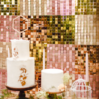 backdrop met koperen, rose en gouden vierkantjes hangt achter een bruilofts taart