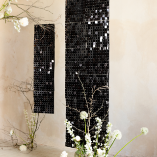 ruimte versierd met zwarte panelen met vierkantjes en witte kunstbloemen