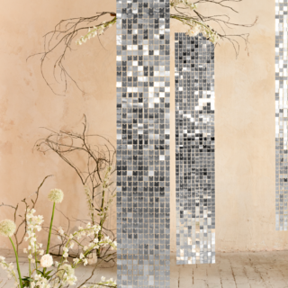 ruimte versierd met zilveren panelen met vierkantjes en witte kunstbloemen