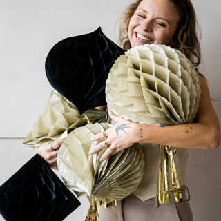 vrouw met drie honeycombs in het zwart en creme met gouden tassels