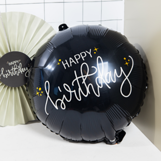 zwarte ballon met de witte tekst happy birthday en gouden sterren