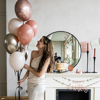 een vrouw poseert met creme en roze ballonnen